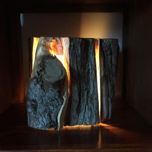 Cracked log lamp with light beaming through the cracks