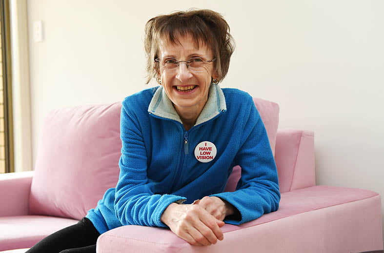 Suzanne sitting on a chair looking at the camera smiling