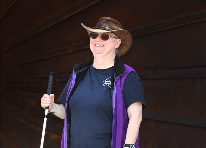 Woman smiling holding a mobility cane