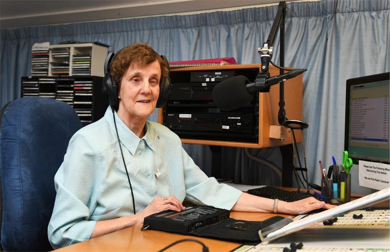 Woman in a radio studio with ear phones on