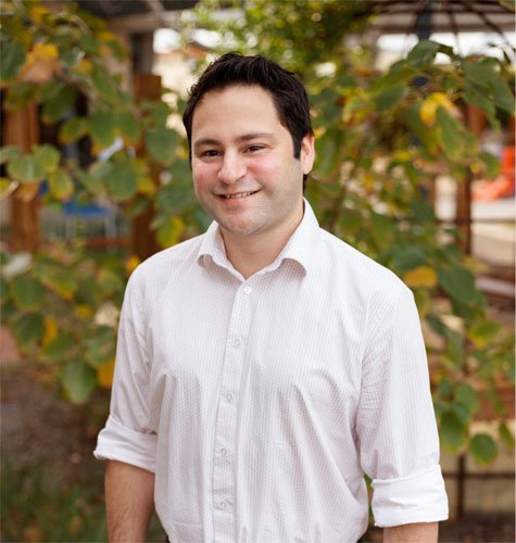 Andrew Lyons, Manager, Specialist Services, smiles while wearing a white shirt.