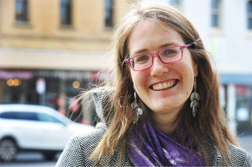 Young woman with glasses looking towards the camera smilling